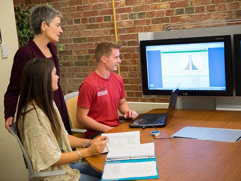 通信专业的学生通过一台连接到mediscape系统的笔记本电脑与教授分享他们的工作