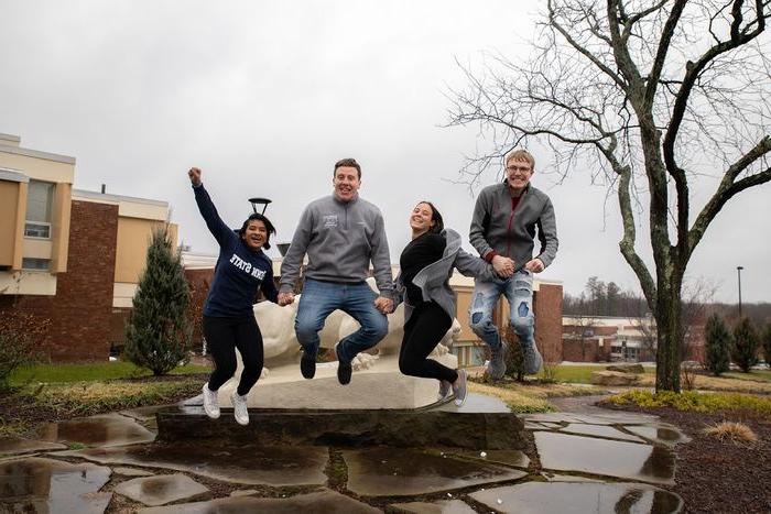 Four students jump in the air