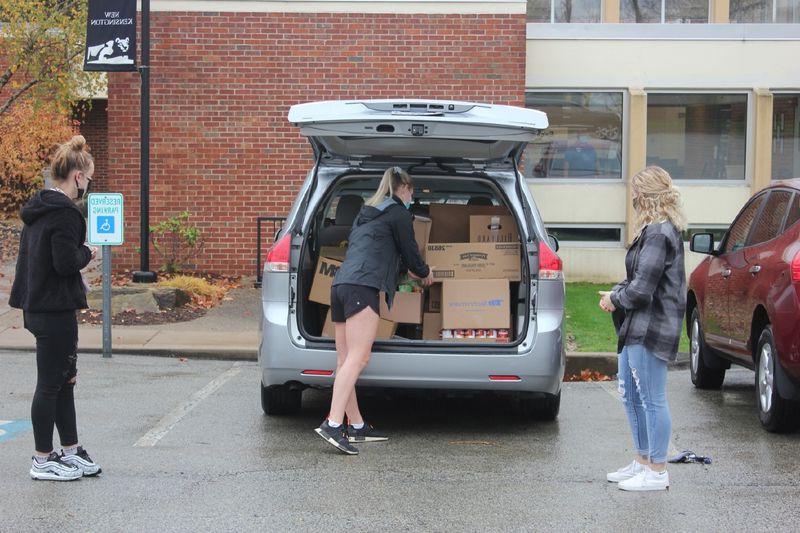 学生将捐赠的食物装上车