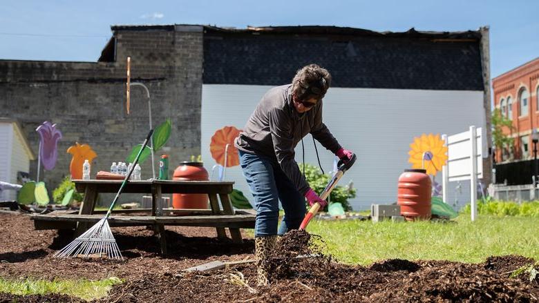 妇女在社区花园铲护根物