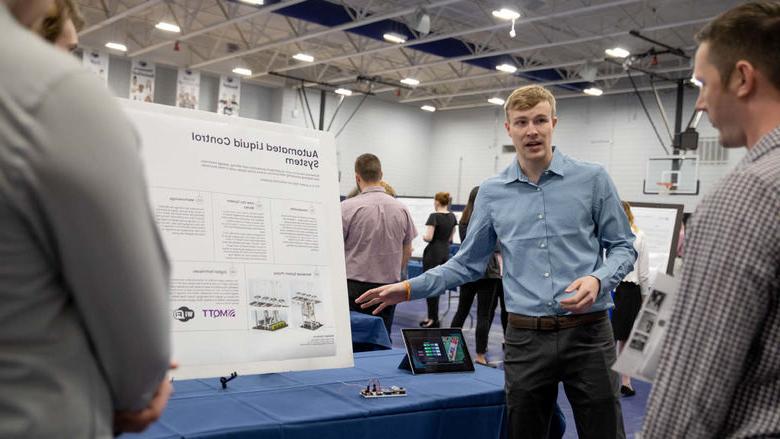 Student presents research project at table