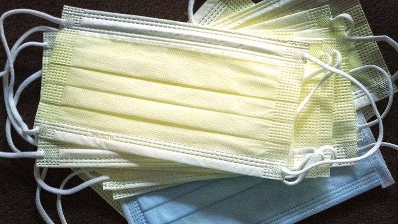 A stack of blue and yellow face masks. 