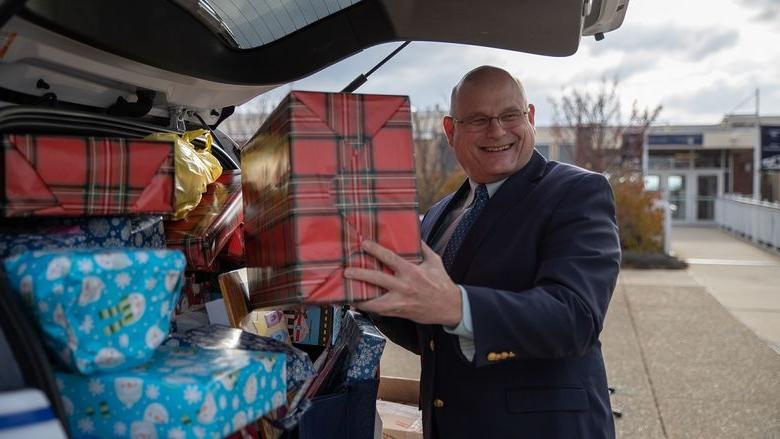 Man puts wrapped gift in car