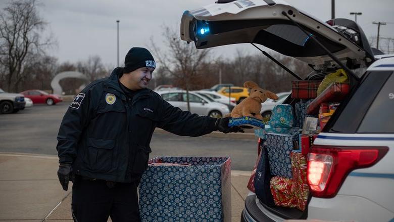 Police officer places gift in car